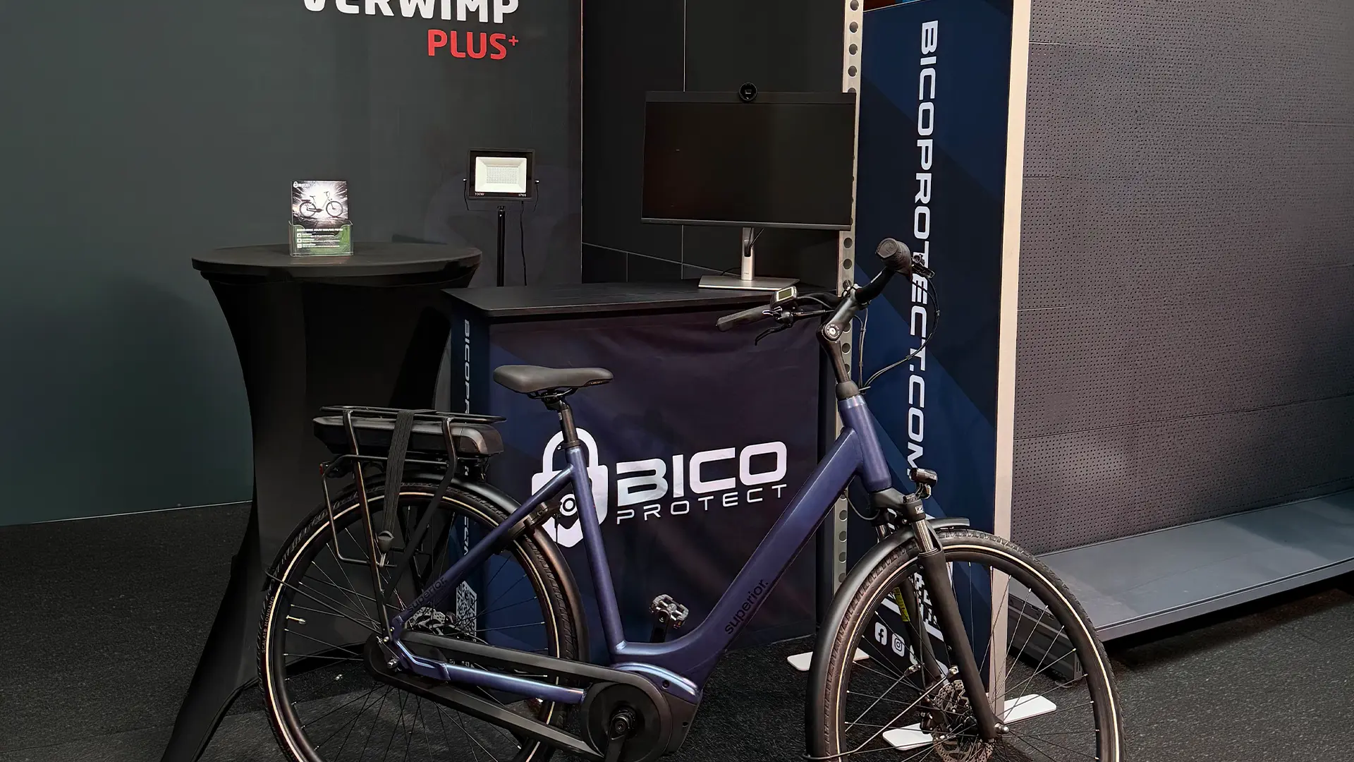 Beursstand van BICO Protect met een donkerblauwe e-bike en een bicoprotect.com-banner