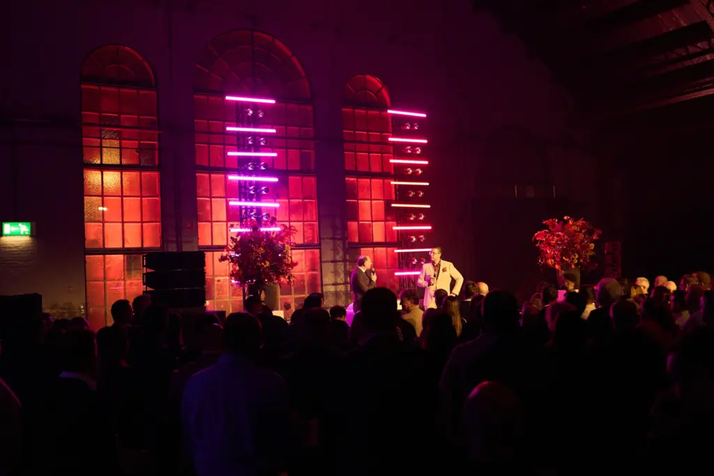 Publiek in de Koepelhal in Tilburg tijdens de BOV Trofee 2025, met roze verlichte boogramen
