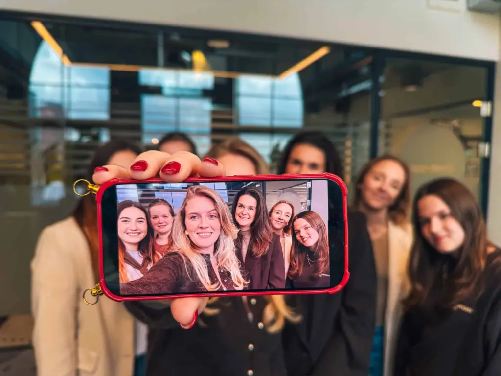 Het team van Strooploos poseert samen voor een groepsfoto op een telefoon